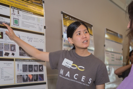 A student explains her research poster at this year's MACES open house.