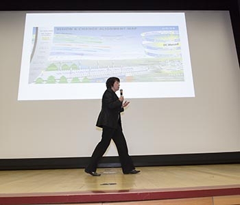 Chancellor Dorothy Leland on stage with the Vision and Change Alignment map projected on a screen behind her.