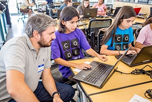 High school girls from Merced, Atwater, Livingston, Ceres and Fresno learn basic computer coding from graduate student Angelo Kyrilov.