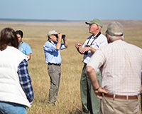 Reserve Manager Chris Swarth, center right, leads a group of scholars, students and community members on a tour of the reserve adjacent to campus.