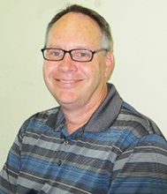 Image of UC Merced staff member Gary Lowe, seated in his office.