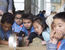 Visiting students watch wheel races as they learn about angular momentum.