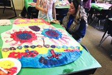 A UC Merced arts student guides the creation of a calavera.