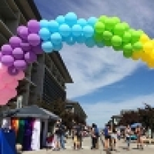 A rainbow-colored balloon  arch decorates Scholars Lane outside of Kolligian Library.