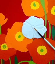An unglazed ceramic poppy is shown on a colorful background.