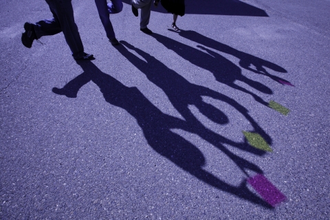 The shadows of four individuals is cast on the ground at UC Merced. 