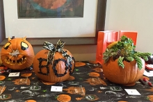 Three decorated Halloween pumpkins on display.