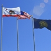 Flags for the State of California, the United States and the University of California fly in the wind at UC Merced.